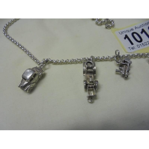 1012 - A long silver chain with six transport related charms,