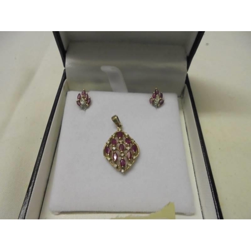 11 - A yellow gold diamond and ruby pendant and earring set, 3.6 grams.