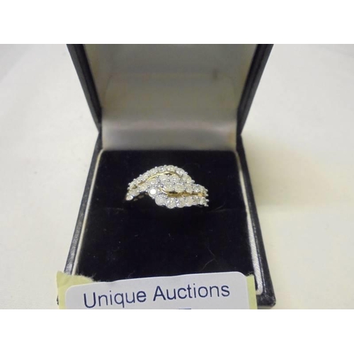 17 - A 9ct yellow gold 98pt three row diamond swirl ring, size R half, 2 grams.