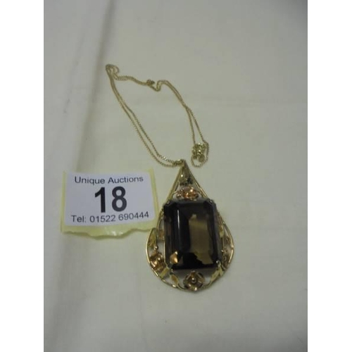 18 - A large 18ct gold pendant set large stone (possibly smoky quartz) on an 18ct (750) chain.