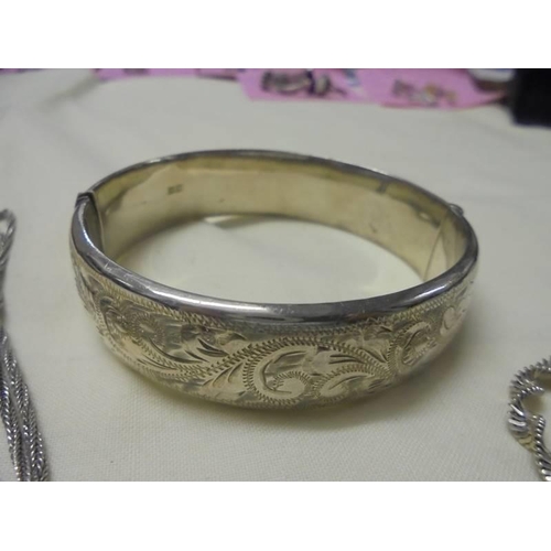 1022 - A silver locket, a silver bracelet and a silver bangle (bangle has dint). 36 grams (1.3 ozs).