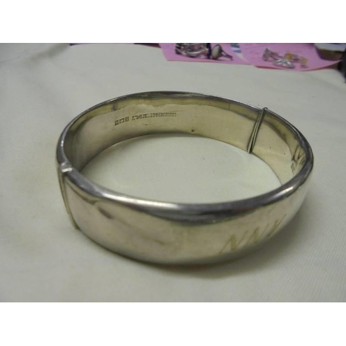 1022 - A silver locket, a silver bracelet and a silver bangle (bangle has dint). 36 grams (1.3 ozs).