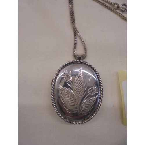 1107 - A silver locket on a silver chain,