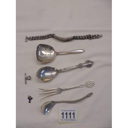 1111 - A Sterling silver identity bracelet, four items of sterling flatware etc.,