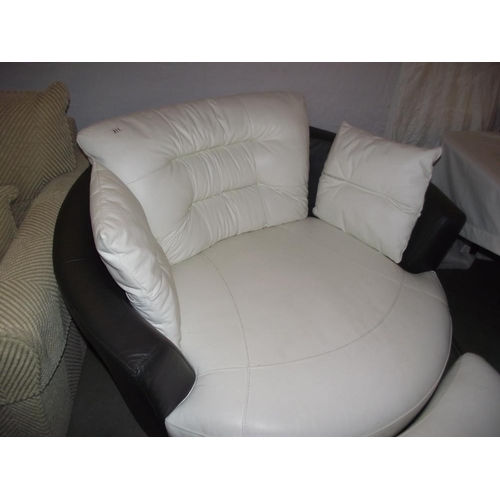 211 - A large black and white leather rotating armchair and footstool  COLLECT ONLY