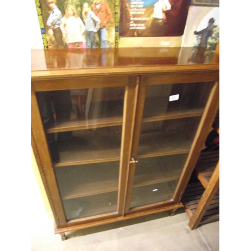 233 - A glazed darkwood bookcase 89cm x 27cm x 122cm