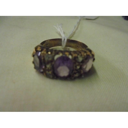 33 - A 9ct gold ring set lilac coloured stones, size P half. (4.5gms)