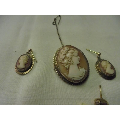 41 - A cameo suite comprising a brooch, a pair of earrings and a single earring all in 9ct gold.