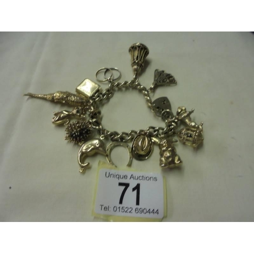 71 - A 9ct gold charm bracelet with forteen charms, 71 grams.