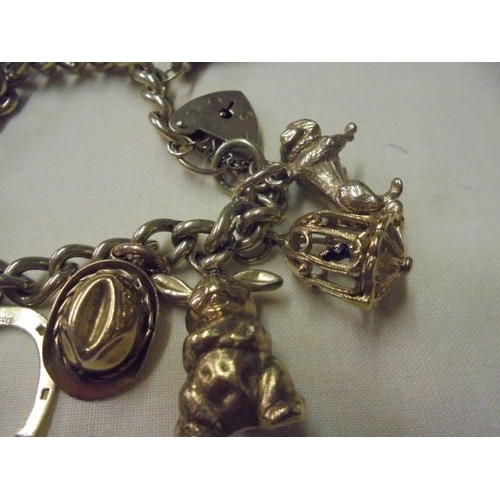 71 - A 9ct gold charm bracelet with forteen charms, 71 grams.