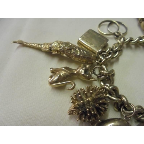 71 - A 9ct gold charm bracelet with forteen charms, 71 grams.