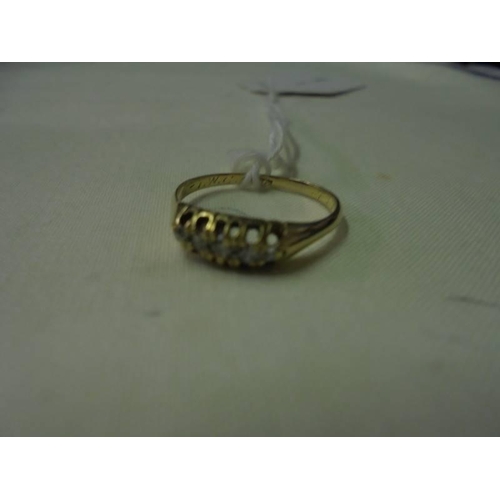 75 - An 18ct gold ring set with five diamonds (approximately 0.15 ct), size O, 2.2 grams.