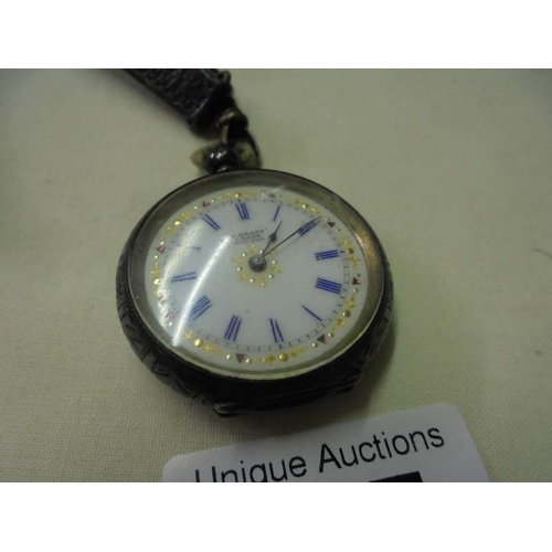 157 - A Victorian ladies silver fob watch on a leather strap.