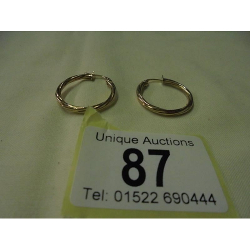 87 - A pair of 9ct gold twist earrings, 1 gram.
