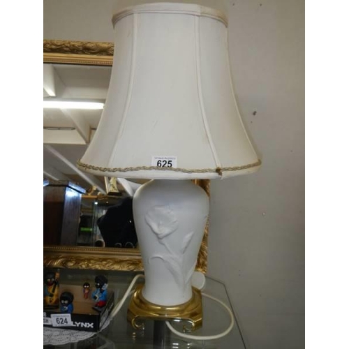 625 - A white porcelain table lamp on a brass base.