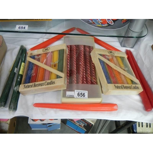 656 - Two packets of natural beeswax candles, a box of nine candles and two others.