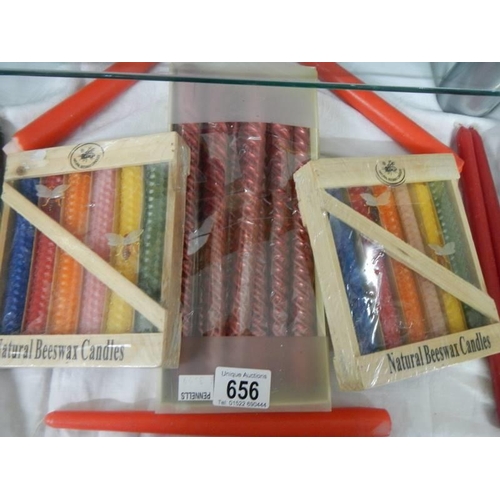 656 - Two packets of natural beeswax candles, a box of nine candles and two others.