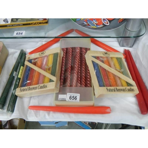 656 - Two packets of natural beeswax candles, a box of nine candles and two others.