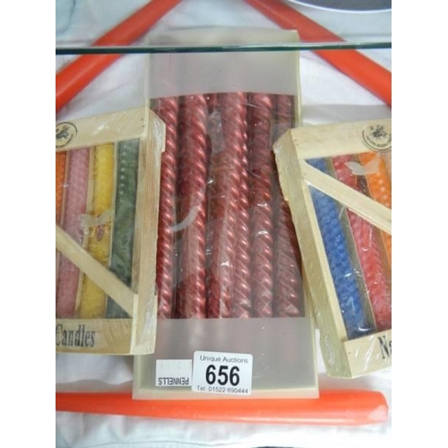 656 - Two packets of natural beeswax candles, a box of nine candles and two others.