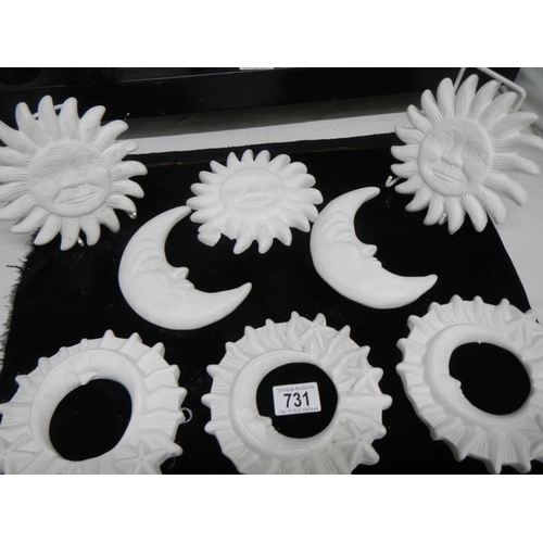 731 - A quantity of plaster moon and sun wall ornaments.