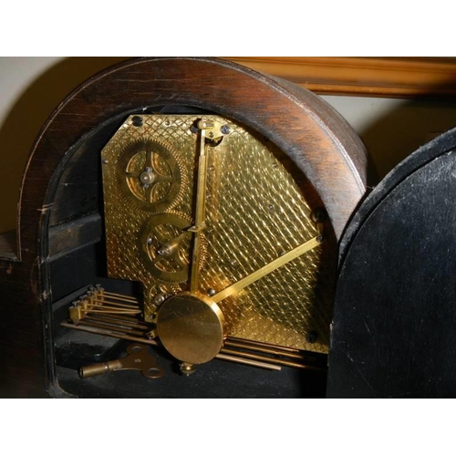 747 - A 1938 oak mantel clock (for 51 years service), with key and in working order.