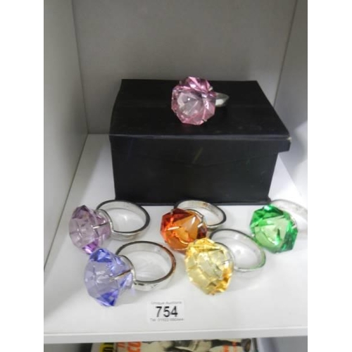 754 - A set of six coloured glass and metal napkin rings in the style of a solitaire ring.