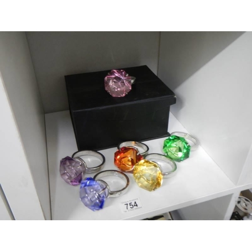 754 - A set of six coloured glass and metal napkin rings in the style of a solitaire ring.