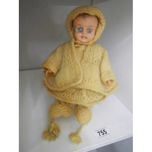 755 - A vintage doll in hand knitted clothing.