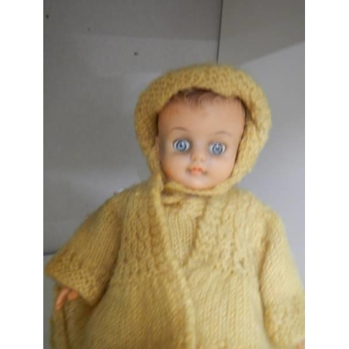 755 - A vintage doll in hand knitted clothing.