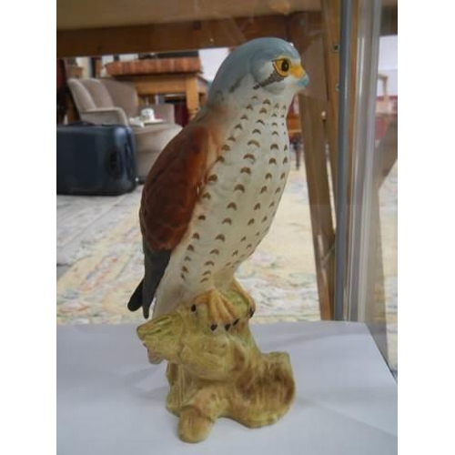 837 - Two Beswick bird figures and a Merlin by Royal Doulton for Whyte and Mackay.