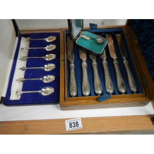 838 - A cased set of knives and forks (missing 2 forks) and a cased set of spoons.