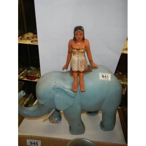 944 - A large painted wooden elephant with a figure on its back, height 40 cm, length 39 cm, COLLECT ONLY