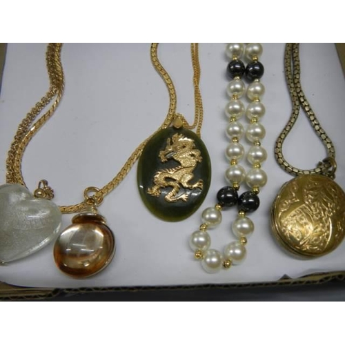 955 - A selection of necklaces including a jade dragon pendant.