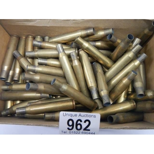 962 - A box of spent brass rifle shells.