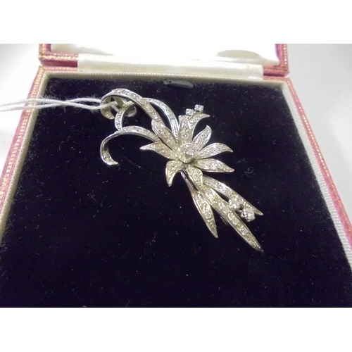 103 - A superb quality 18ct white gold and diamond set brooch as a flower spray. (11.8gms)
