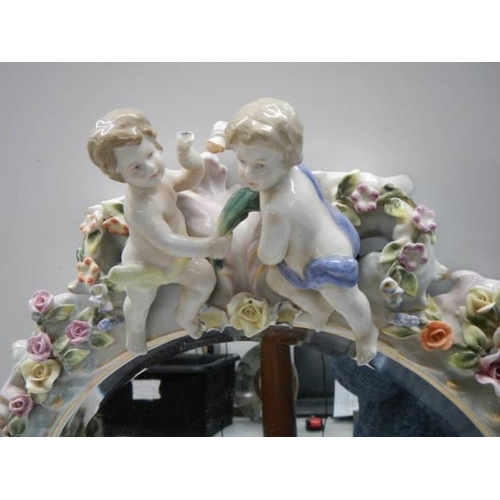 319 - A 20th century porcelain framed mirror with cherubs and flowers, COLLECT ONLY.