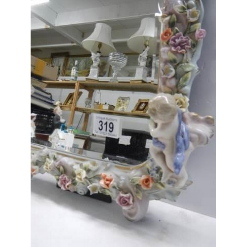 319 - A 20th century porcelain framed mirror with cherubs and flowers, COLLECT ONLY.