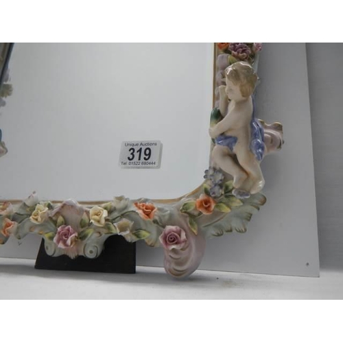 319 - A 20th century porcelain framed mirror with cherubs and flowers, COLLECT ONLY.