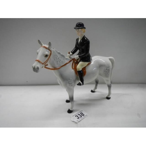 338 - A Beswick horse with black jacket huntsman, 23 cm tall.