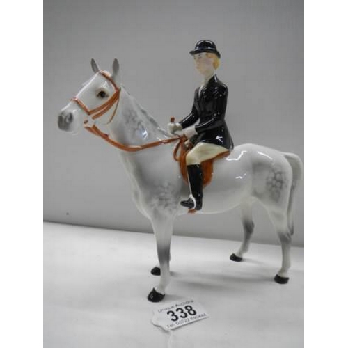 338 - A Beswick horse with black jacket huntsman, 23 cm tall.