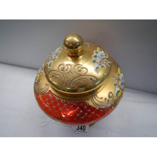 340 - A red Murano glass lidded vase with gold and floral decoration.