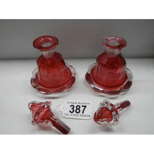 387 - A pair of red glass perfume bottles.