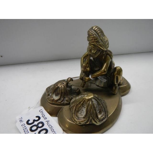 389 - An antique brass figure of a snake charmer.