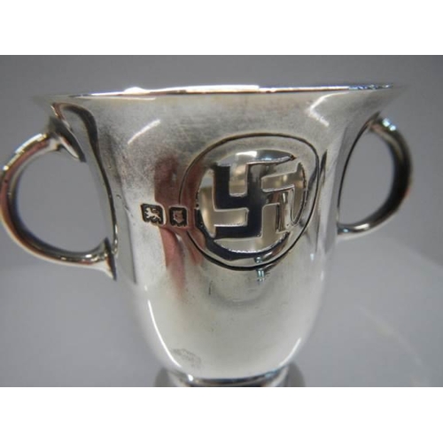 397 - A small two handled silver cup with Swastika symbol.