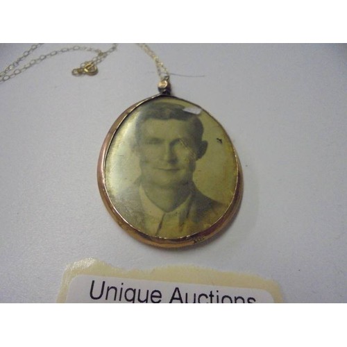150L - A 9ct gold double sided photo locket on a 9ct gold chain.