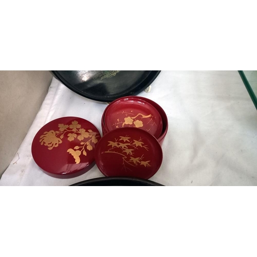 2201 - 2 Oriental scenes on black lacquered trays and red lacquered box of coasters, could also be used as ... 