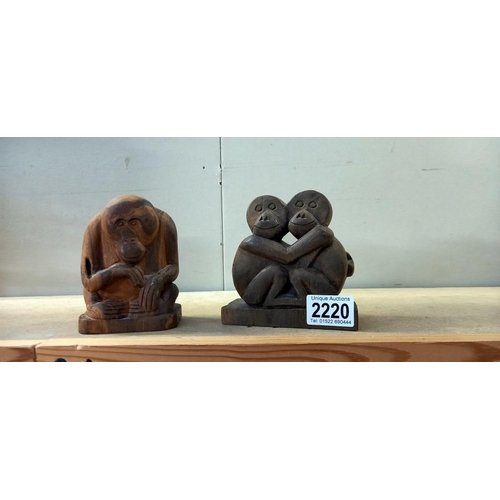 2220 - A carved wood figure of an orangutan and another carved ape figure