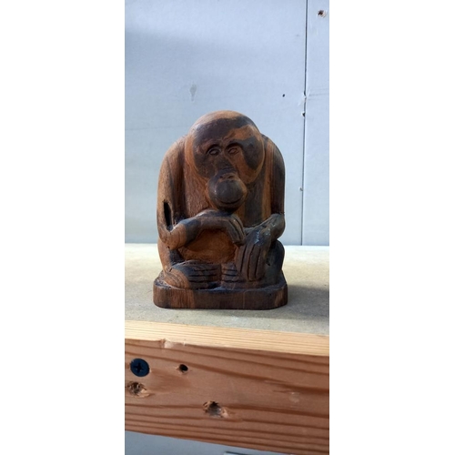 2220 - A carved wood figure of an orangutan and another carved ape figure