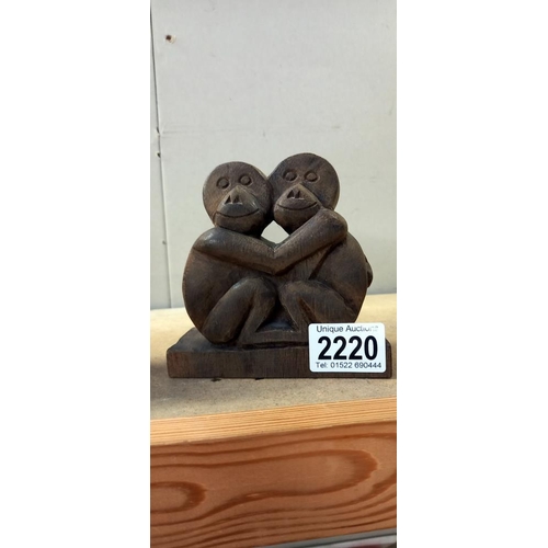 2220 - A carved wood figure of an orangutan and another carved ape figure