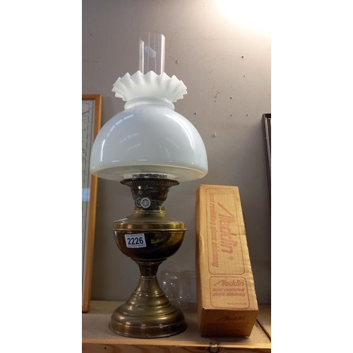 2226 - A vintage brass oil lamp and shade, plus a boxed Aladdin Loxon chimney